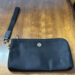 Lululemon wristlet in black with gold hardware. Great as a clutch.